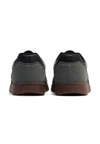 Szare zamszowe trampki z fakturowanym czarnym akcentem z naturalnej skóry, posiadające brązową gumową podeszwę oraz geometryczny wzór na pięcie.