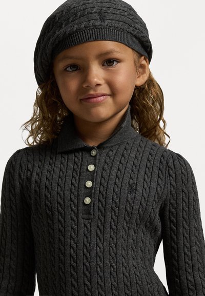 Tumši pelēkā krāsā adīts džemperis ar apkakles izgriezumu, kuram ir pieci apaļi pogas un atbilstoša adīta berete.