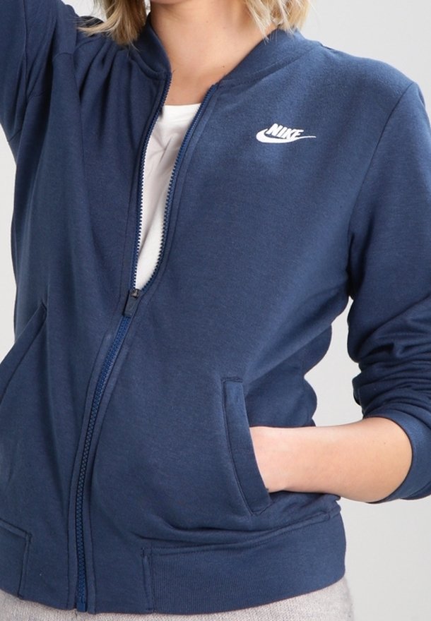 Marinblå zip-up hoodie tillverkad av en blandning av bomull, med en vit Nike-logotyp på bröstet, sidofickor och ribbade ärmslut.