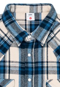 Karierte Flanellshirt in Creme-, Marine- und Blautönen. Verfügt über einen Knopfkragen und zwei Fronttaschen. Weicher Stoff mit auffälligem Karomuster.