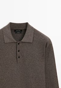 Braunes geripptes langärmliges Poloshirt mit drei schwarzen Knöpfen und klassischem Kragen, mit dem Label Massimo Dutti, 100 % Baumwolle.