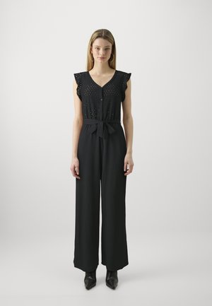 Combinaison noire avec des manches à volants, fermeture à boutons sur le devant, ceinture en tissu et jambes larges. Tissu texturé avec des détails en découpe subtils sur l'ensemble.