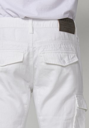 Pantaloni cargo bianchi realizzati in misto cotone, con due tasche posteriori con pattina, un piccolo etichetta in pelle sulla cintura e un taglio classico.