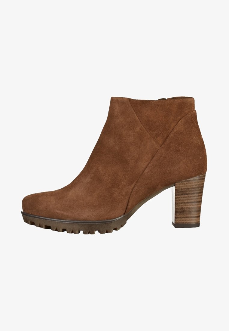 Bottine en daim marron à bout rond, talon bloc en bois et semelle texturée. Présente une découpe latérale pour plus de détails.