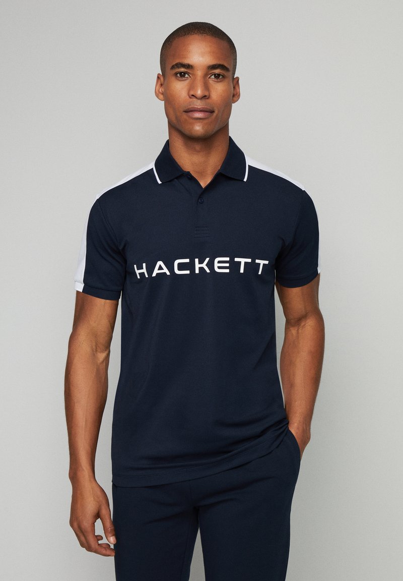 Námornícky polo tričko s bielymi akcentmi, s golierom a výrazným logom "HACKETT" na hrudi. Vyrobené z hladkého textilu.
