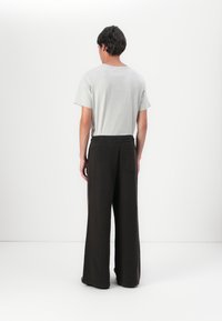 Marimekko PUUSKA VIHKIRUUSU PLACEMENT UNISEX - Tracksuit bottoms - dark brown