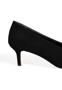 Zwarte suède hoge hak schoenen met een spitse neus en een slanke hak. De hak heeft een gouden accent aan de basis. Over het geheel gezien een gladde textuur.