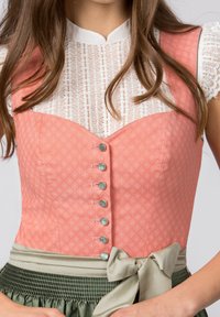Rosa gemusterter Dirndl-Oberteil mit heller Spitze, verziert mit silbernen Knöpfen und einem grünen Satinband in der Taille, das einen geschichteten Effekt erzeugt.
