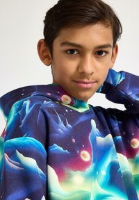 Felpa con cappuccio in tessuto morbido caratterizzata da un vivace tema spaziale con colori come blu, viola e rosso, che mostra pianeti e stelle.