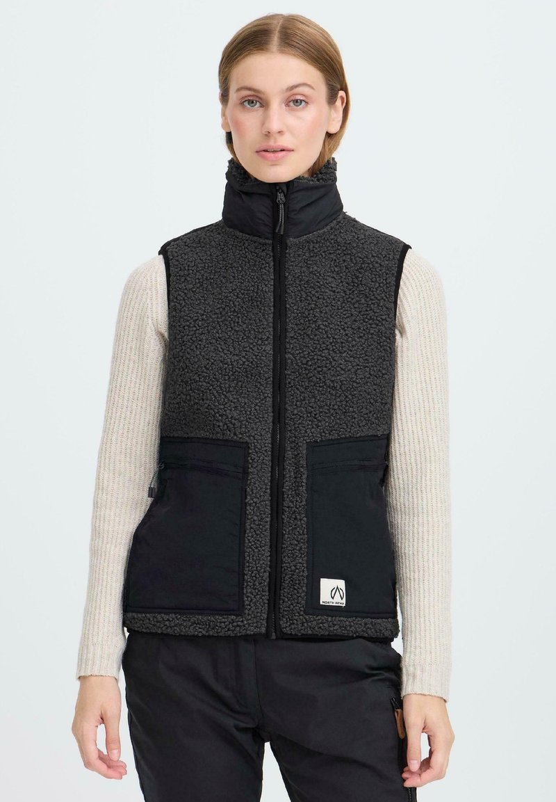 Schwarz-graue Fleece-Weste mit Stehkragen, Frontreißverschluss, zwei großen Taschen und einem Logo-Patch am unteren Ende. Texturiertes Material.