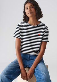Gestreepte t-shirt met korte mouwen in zwart en wit, met een ronde halslijn en een geborduurd rood hartje op de linkerborst. Casual pasvorm, katoenmix.