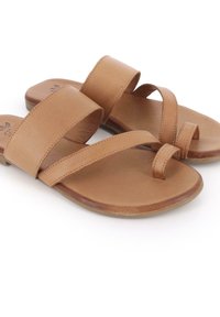 Sandalias planas de cuero marrón con dos correas anchas y un bucle en el dedo del pie, con un acabado mate suave y un diseño de suela plana.