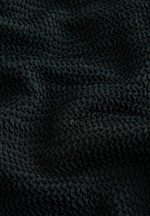 Černá texturovaná látka s vlnitým vzorem, na které jsou malé, souvislé skladby, vytvářející na povrchu materiálu vlnitý efekt.