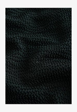 Tejido negro texturizado con un patrón ondulado, con pequeños pliegues consistentes que crean un efecto ondulado en la superficie del material.