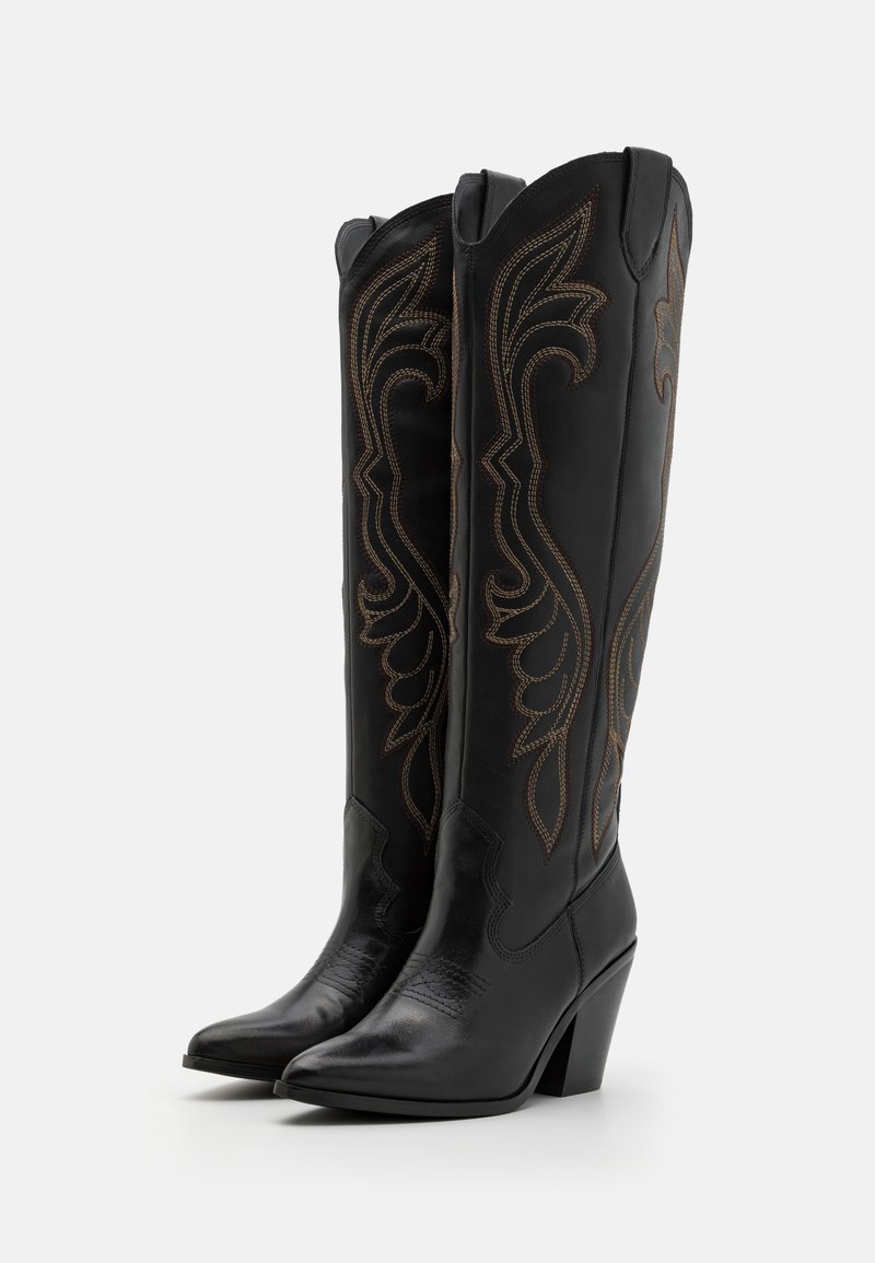 Botas de vaquero de cuero negro con punteras puntiagudas y un tacón de 3 pulgadas. Diseños bordados marrones intrincados adornan el caña. Acabado texturizado en las puntas.