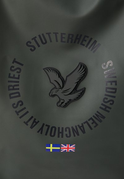 Zeleni vodootporni materijal s crnim utisnutim logom orla, kružnim natpisom "STUTTERHEIM SWEDISH MEWELANCHOTY" i detaljima zastave.