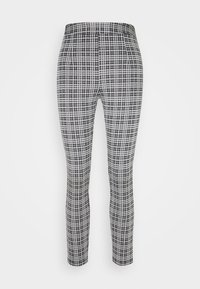 Svarta och vita rutiga leggings i ett stretchigt tyg. Mönstret har en rutnätsdesign, mjuk textur och elastisk midjeband för komfort.
