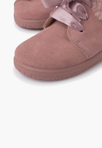 Zapatos de ante rosa con punta redonda, que presentan una cinta de satén para atar y suaves acentos de piel de pelo alrededor de la abertura. Suela de goma para mayor agarre.