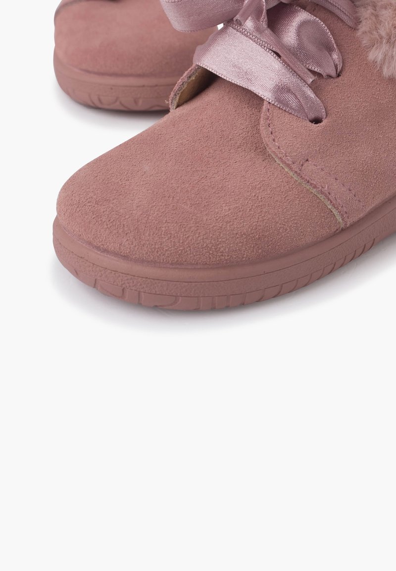 Zapatos de ante rosa con punta redonda, que presentan una cinta de satén para atar y suaves acentos de piel de pelo alrededor de la abertura. Suela de goma para mayor agarre.