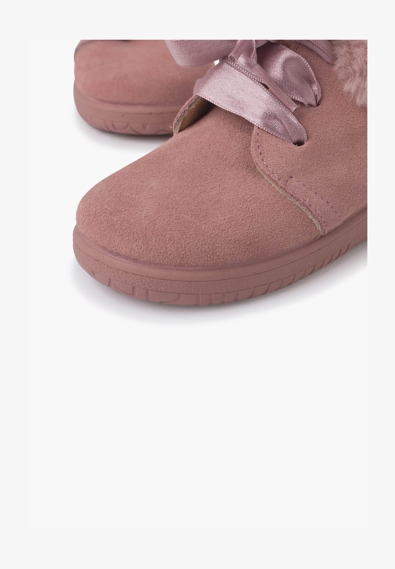 Zapatos de ante rosa con punta redonda, que presentan una cinta de satén para atar y suaves acentos de piel de pelo alrededor de la abertura. Suela de goma para mayor agarre.