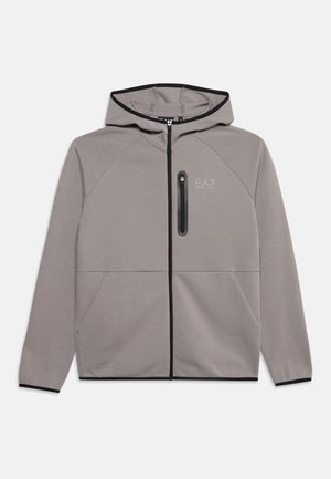 Veste à capuche zippée gris clair avec bordure noire, poche poitrine zippée et logo EA7 Emporio Armani sur le côté gauche de la poitrine.