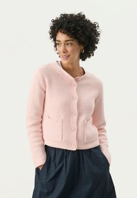 Pink textured cardigan with a round neckline, front button closure, and two pockets. Ribbed cuffs and hem with a fitted silhouette.