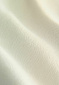 Puuvillakangas sileässä, off-white värissä, jossa on hieno rakenne ja hienovaraiset vinoraita-kuviot. Ihanteellinen erilaisiin tekstiilikäyttöihin.