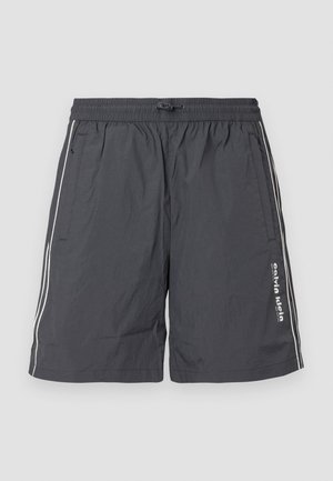 Šedé, lehké šortky s elastickým pasem a stahovací šňůrkou. Obsahují bílé boční pruhy a detail loga na levé noze.