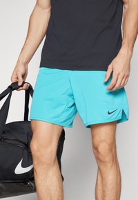 Pantalones cortos turquesa de Nike con logo negro, fabricados en tejido ligero, con un corte relajado y costuras laterales para mayor libertad de movimiento.