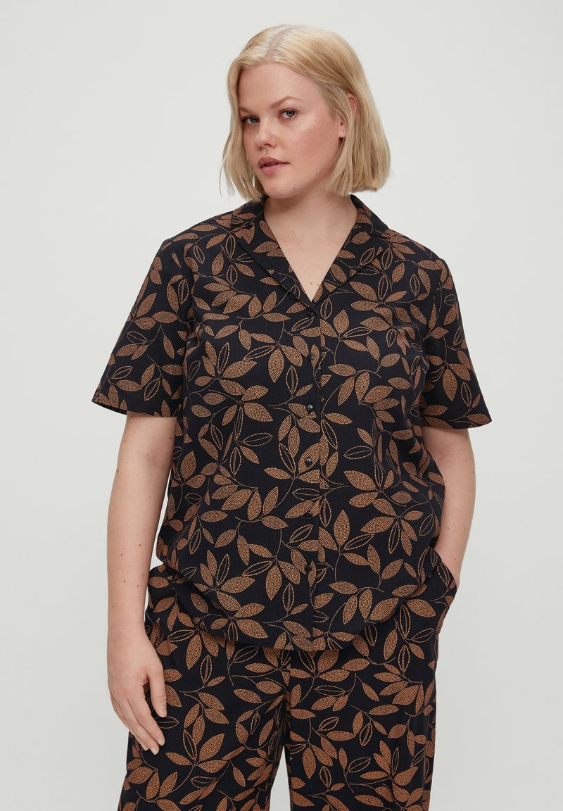 Camisa negra de manga corta con un patrón de hojas beige en toda la prenda, con cuello de solapa y cierre de botones, hecha de tela ligera.