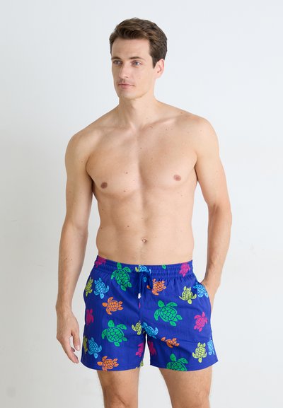Blauwe zwembroek met kleurrijke schildpadpatronen in oranje, groen, roze en blauw. Elastische tailleband met verstelbare koorddetail.