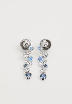 Srebrne kolczyki z wieloma kamieniami szlachetnymi w odcieniach niebieskiego i przezroczystego, o różnych rozmiarach i zgrupowanych elementach wzorniczych.