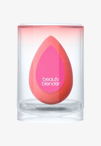 Beauty Blender rosa, spugna a forma di uovo, confezionata in un contenitore cilindrico trasparente. Il testo riporta "beauty blender" e "wet.squeeze.bounce."