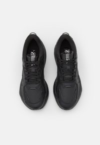 Baskets de sport noires avec une empeigne synthétique texturée, une languette rembourrée et des lacets noirs. Dotées de sections perforées et d'une semelle extérieure en caoutchouc.