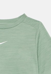 Svetlozelené športové tričko s okrúhlym výstrihom, krátkymi rukávmi a textúrovanou tkaninou. Má malú bielu nálepku Nike na prednej strane.