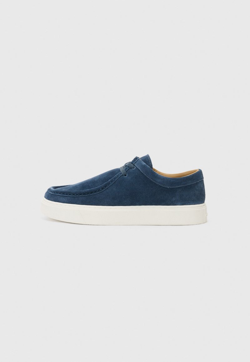 Marineblå skinnslippers med hvit gummisåle, med detaljert søm og rund tådesign. Glatt tekstur totalt.