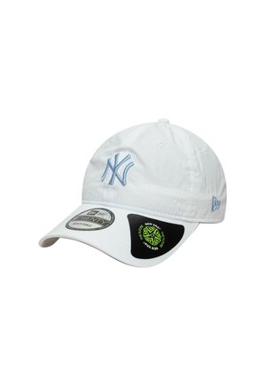 White baseball cap made of fabric, featuring a light blue embroidered logo on the front, adjustable strap, and black sticker on the side.