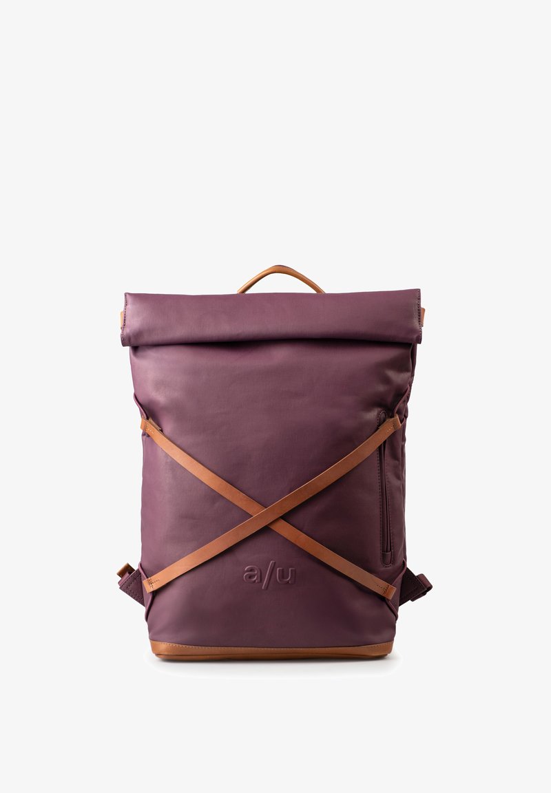 Zaino color bordeaux con design a roll-top, caratterizzato da dettagli in pelle color tan e spallacci diagonali. Include una tasca laterale con zip e un logo impresso.