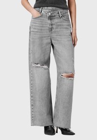 Grijze denim jeans met wijde pijpen, versierd met beschadigde accenten en gefranjerde zomen, en voorzien van een klassieke vijf-pocketstijl en een knoopsluiting.