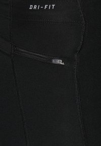 I leggings neri Dri-FIT presentano un materiale elegante e elasticizzato con una tasca zip laterale, cuciture rinforzate e una finitura liscia.