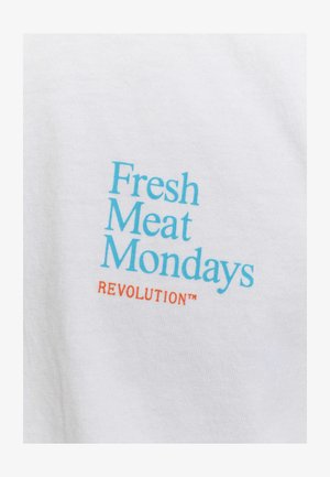 Witte katoenen T-shirt met daarop "Fresh Meat Mondays" in lichtblauw en "REVOLUTION™" in oranje. Zachte textuur met duidelijke, contrasterende tekst.