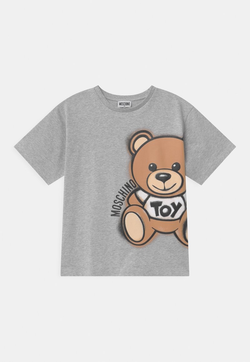 Harmaa puuvillapaita, jossa on sarjakuvakarhun graafinen kuvio ja tekstit "MOSCHINO" ja "TOY". Lyhyet hihat, pyöreä kaula-aukko, pehmeä tekstuuri.