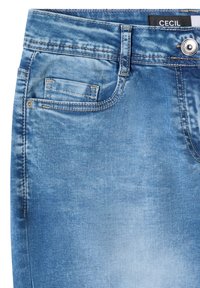 Jean en denim bleu en gros plan montrant la poche avant, petite poche à monnaie, fermeture à bouton, passant de ceinture et étiquette de marque "CECIL" sur la taille.