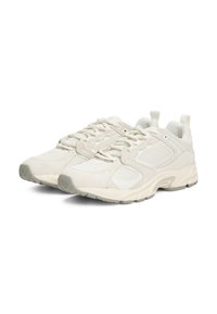 Lys beige treningssko med en blanding av mesh- og semsket skinnmateriale, en polstret krage og en teksturert gummisåle.
