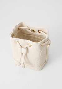 Cream leather bucket bag with gold hardware, drawstring closure, and embossed floral design. Interior features a branded tag.