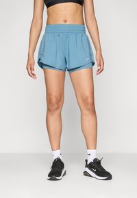 Pantalones cortos deportivos azules hechos de tela ligera con una cinturilla elástica, con un diseño en capas y un pequeño logo de Nike en el lateral.