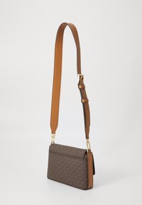 Brown patterned crossbody bag with a tan adjustable strap, gold hardware accents, rectangular shape, and textured surface.
