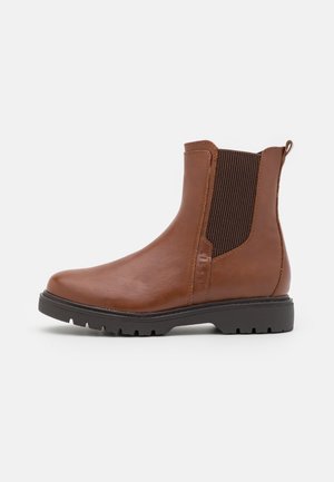 Botte Chelsea en cuir marron avec panneau latéral élastique noir, semelle crantée noire et languette à l'arrière, visible de profil sur fond blanc.