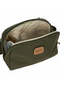 Borsetta rettangolare verde oliva con interno beige, apertura con zip e un piccolo oggetto bianco visibile all'interno.