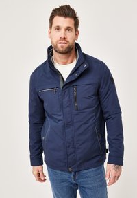 Navy blue jacket with a stand-up collar, zippered chest pocket, and side pockets; features a smooth texture and contrast stitching details.